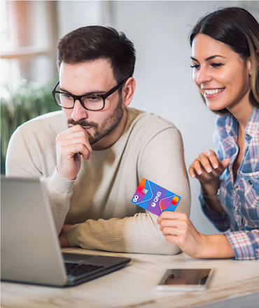 GO QNB yazılı kredi kartını tutan kadın ve dizüstü bilgisayara bakan gözlüklü adam.